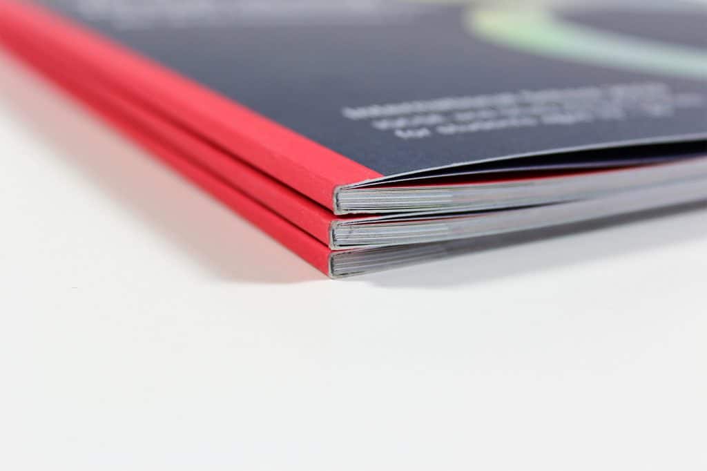 Close-up of printed School Prospectus with dark blue cover and rainbow foil